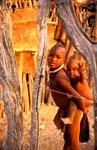 Himba boy carrying child