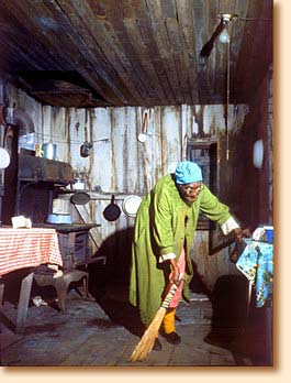 Old woman sweeping shack